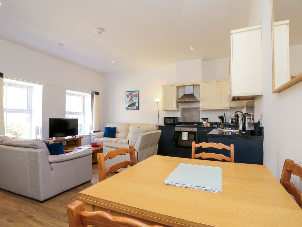 A living room with a sofa, dining table, and kitchen area at Chestnut Cottage in Bridlington