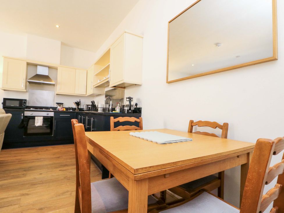 A kitchen with a dining table and wooden chairs at Chestnut Cottage in Bridlington