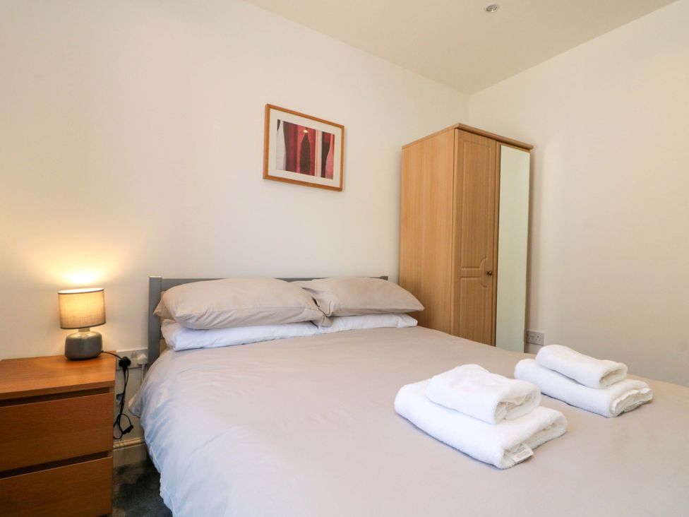 A bedroom with a bed and a wardrobe at Chestnut Cottage in Bridlington