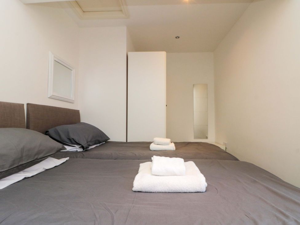 A bedroom with two beds and a wardrobe at Chestnut Cottage in Bridlington