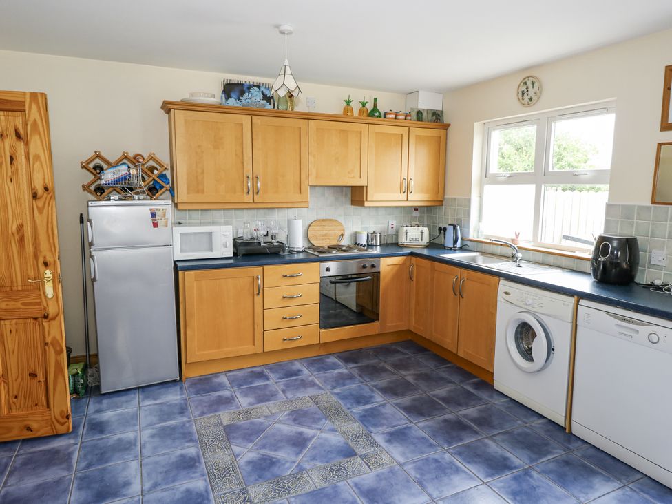 A kitchen with appliances and cabinets at 22 White Maples in Bundoran, County Donegal