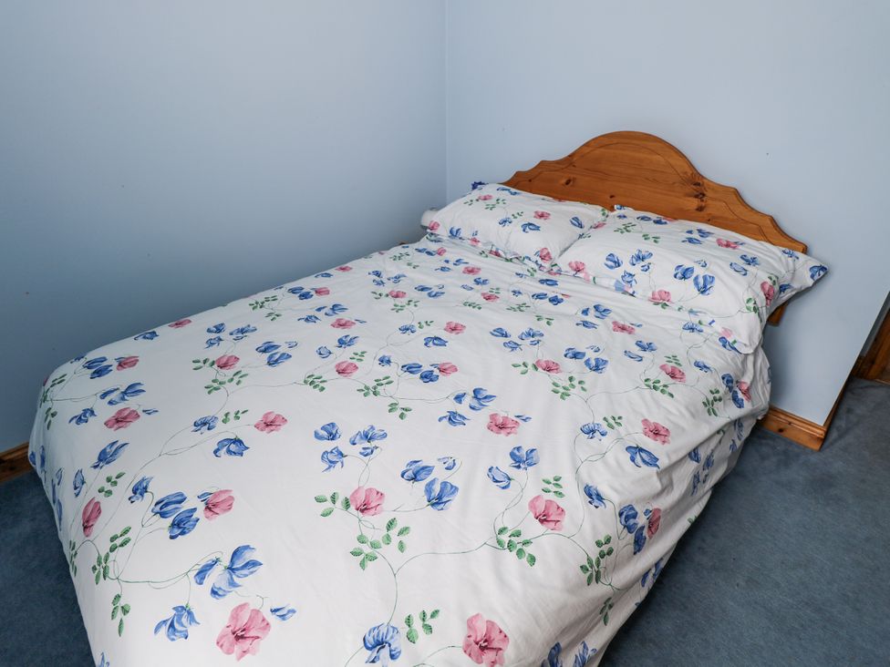 A bed with floral sheets and pillows at 22 White Maples in Bundoran, County Donegal