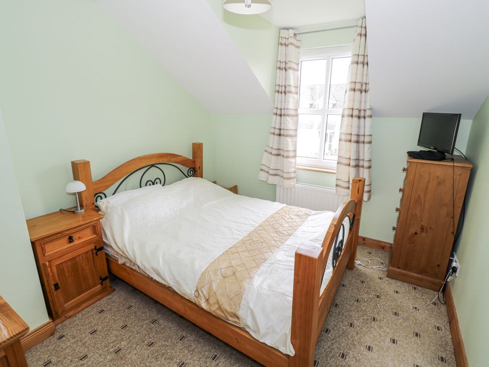 A bedroom with a bed, nightstand, and television at 22 White Maples in Bundoran, County Donegal