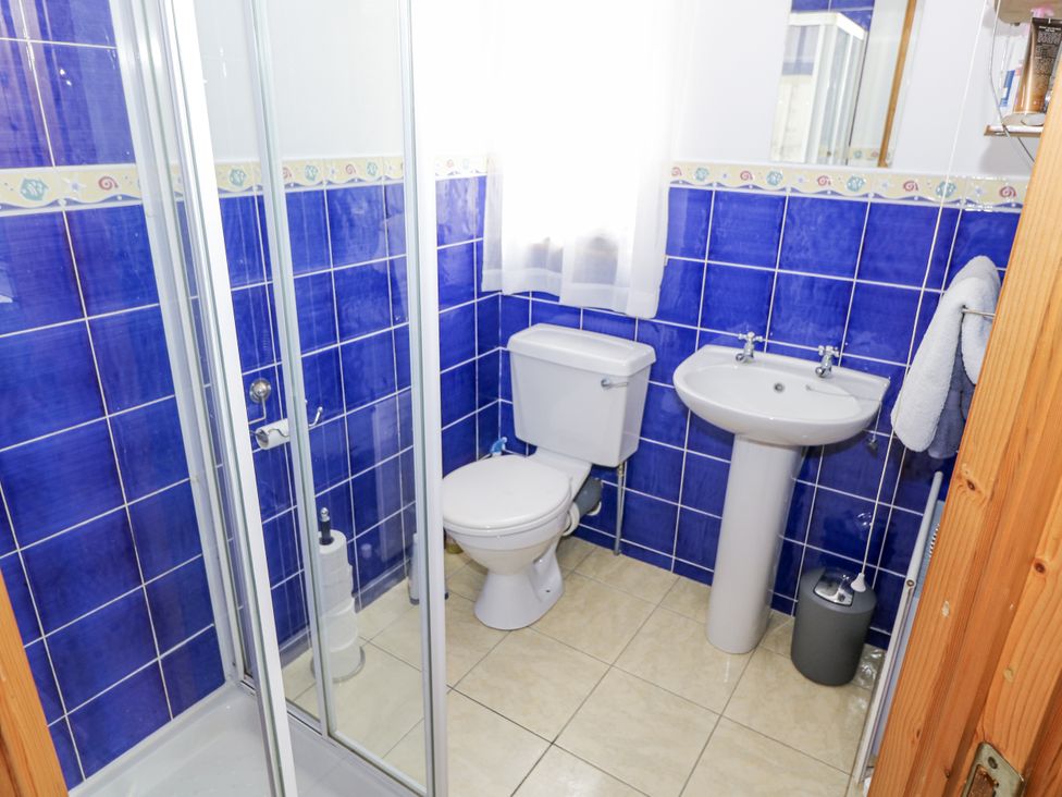 A bathroom with a shower, toilet, and sink at 22 White Maples, Bundoran, County Donegal