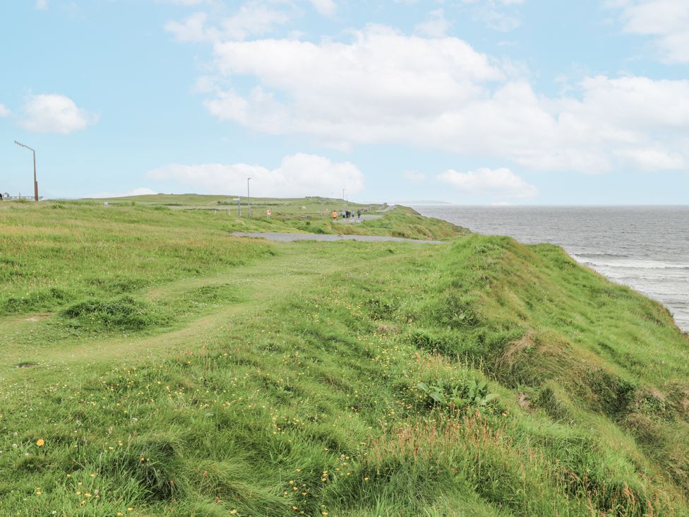 A coastal view with grass and a road near the ocean at 22 White Maples, Bundoran, County Donegal