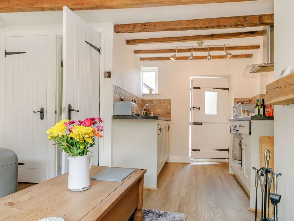 A kitchen with doors and appliances at Chimes Cottage in Guisborough