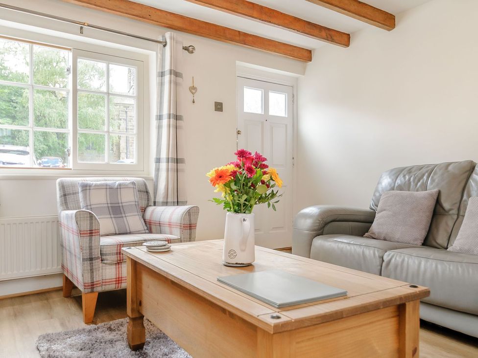 A living room with a sofa and armchair at Chimes Cottage in Guisborough