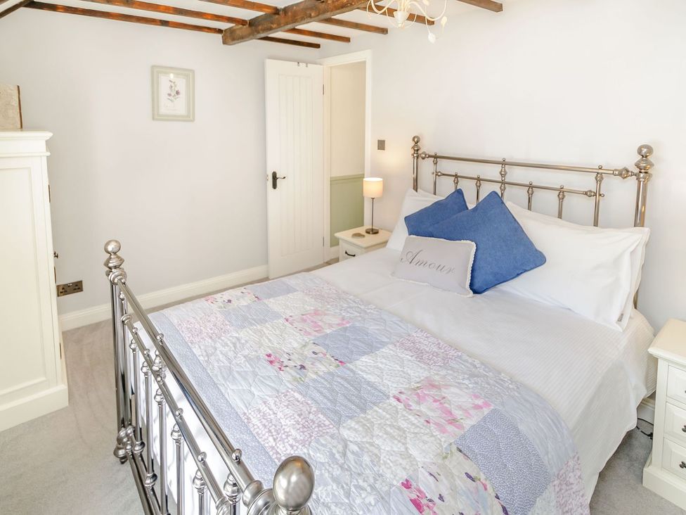 A bedroom with a bed and bedside table at Chimes Cottage in Guisborough