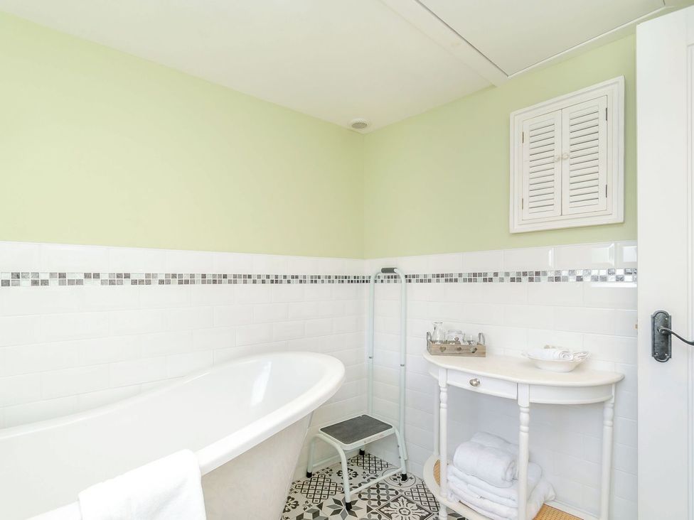 A bathroom with a bathtub and sink at Chimes Cottage in Guisborough