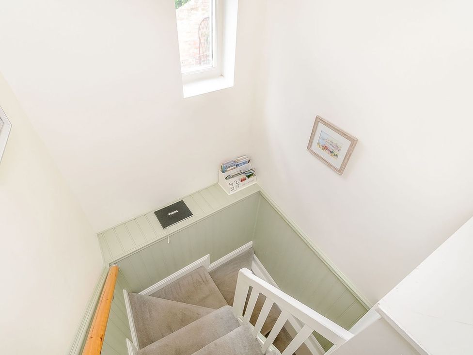 A staircase with a window and framed picture at Chimes Cottage in Guisborough