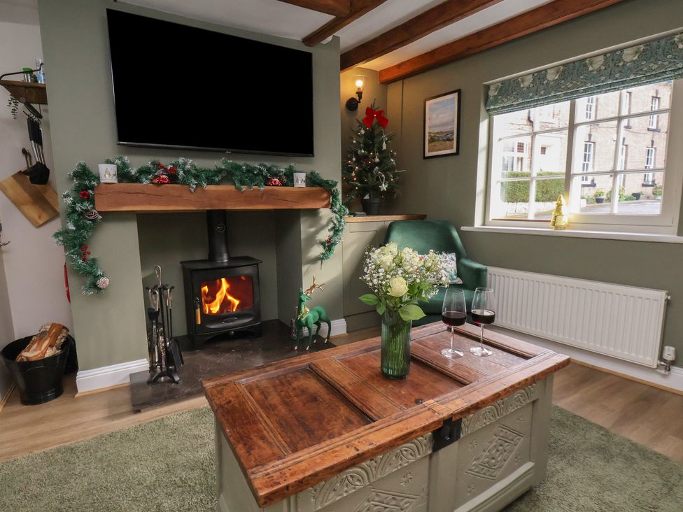 A living room with a fireplace and television at Chimes Cottage in Guisborough