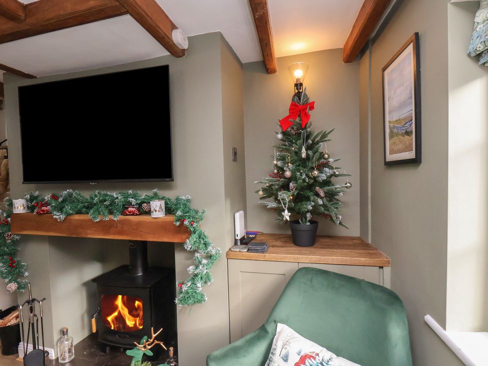 A living room with a Christmas tree and fireplace at Chimes Cottage in Guisborough