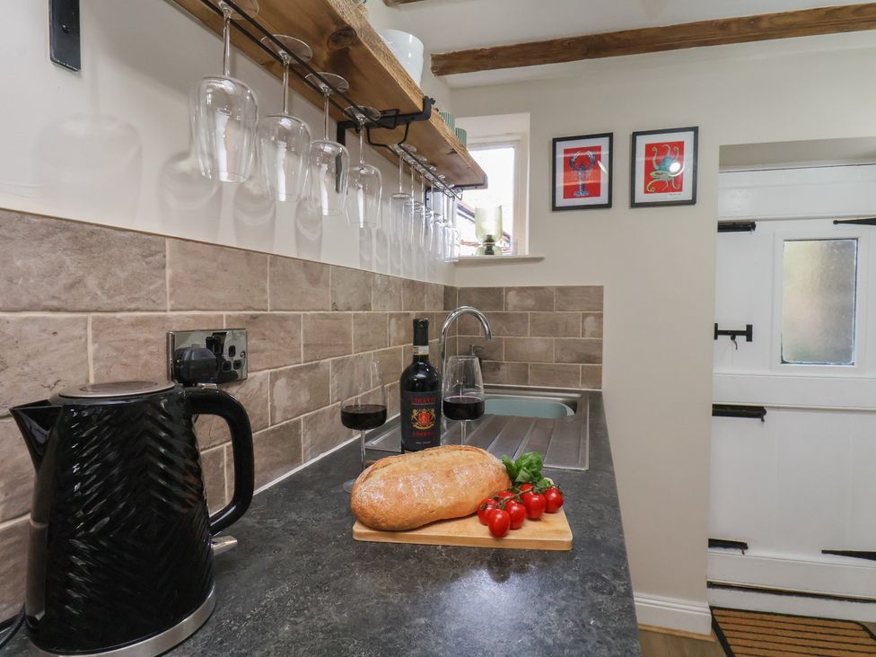 A kitchen with a kettle and wine bottle at Chimes Cottage in Guisborough