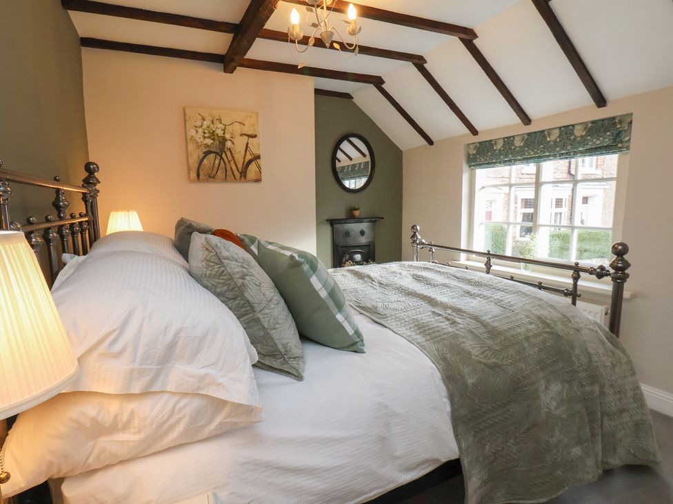 A bedroom with a bed and window at Chimes Cottage in Guisborough
