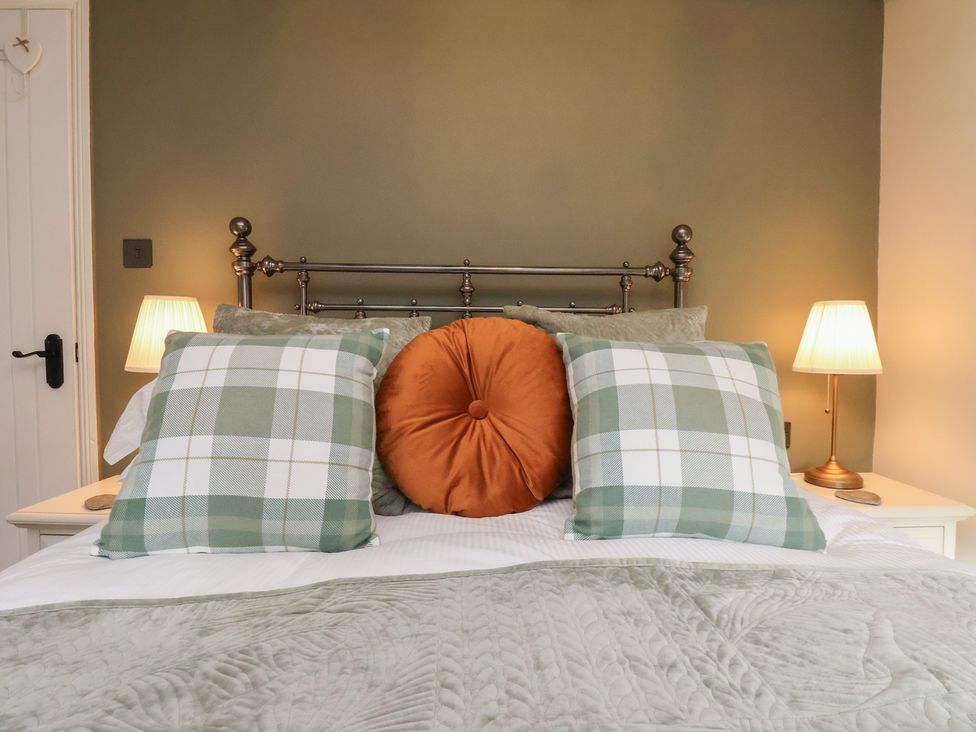 A bedroom with a bed and pillows at Chimes Cottage in Guisborough