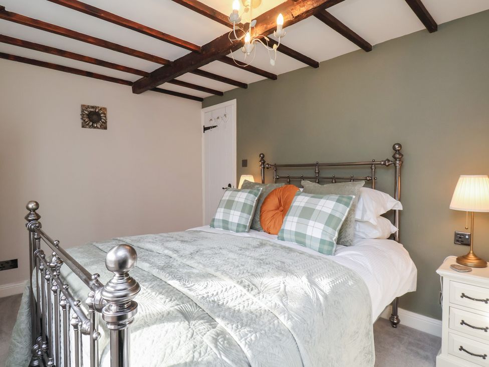 A bedroom with a bed and bedside table at Chimes Cottage in Guisborough