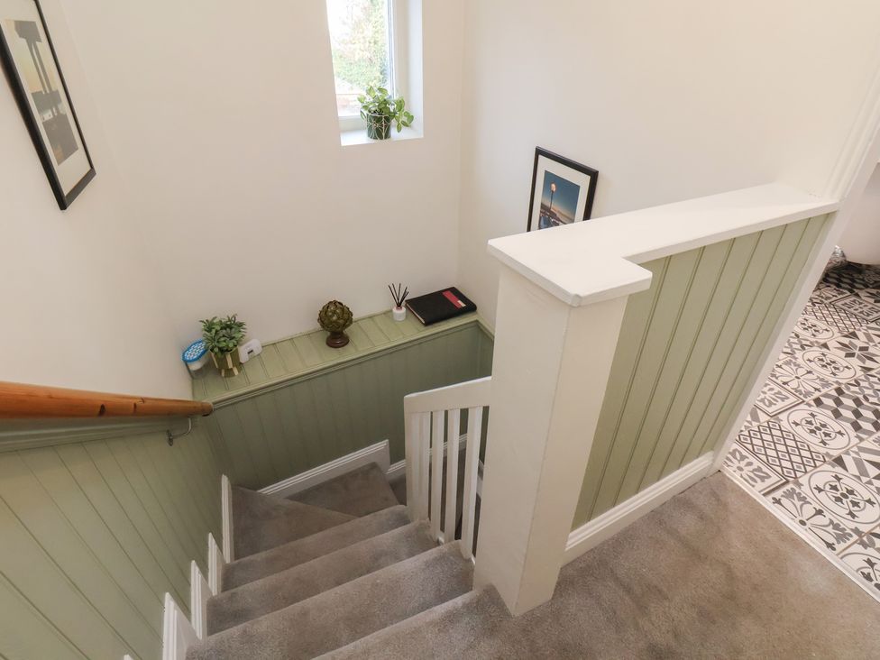 A staircase with a plant and photo frame at Chimes Cottage in Guisborough