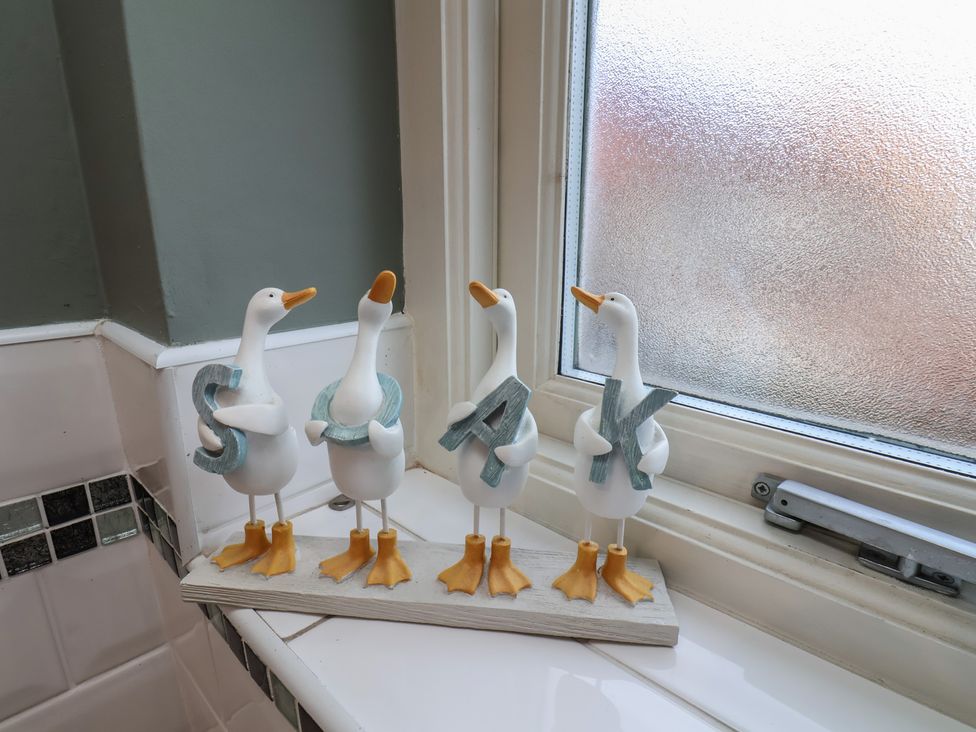 Decorative geese figurines with letters in a bathroom at Chimes Cottage, Guisborough