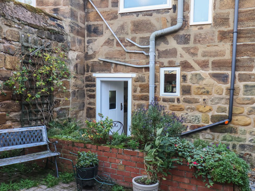A garden with a bench and plants at Chimes Cottage in Guisborough