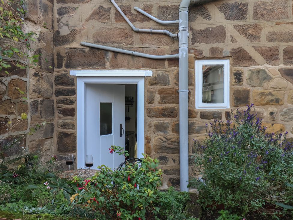 An outdoor area with a door, a window, and plants at Chimes Cottage in Guisborough