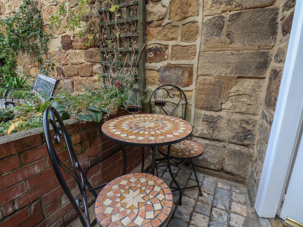 A table and chairs on an outdoor patio at Chimes Cottage in Guisborough
