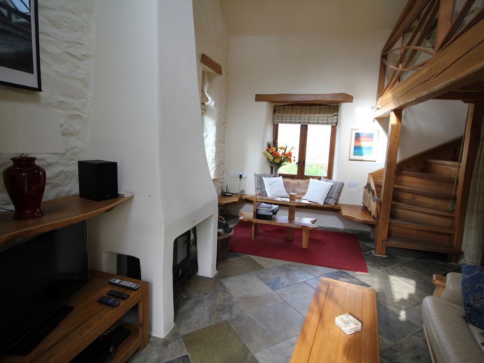 A living room with a fireplace and furniture at The Dovecote in Fishguard