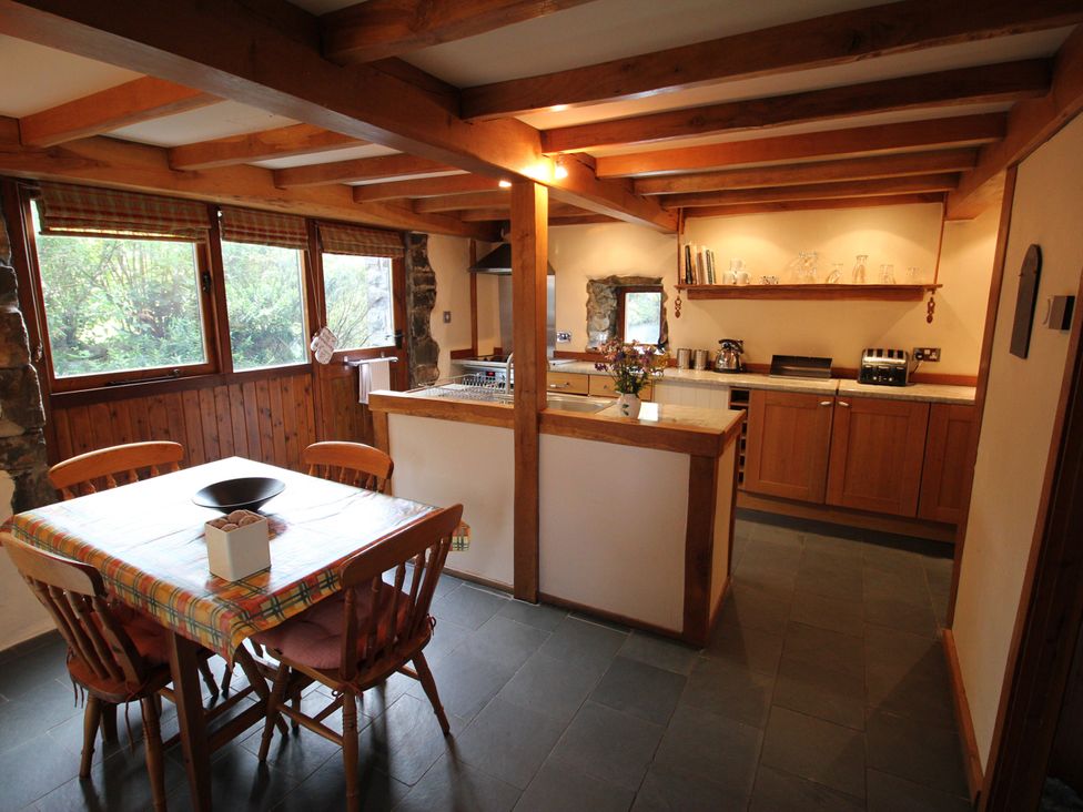 A kitchen with a dining table and chairs at The Dovecote in Fishguard