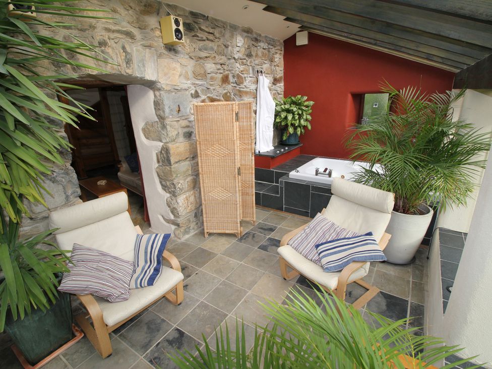 An indoor patio with chairs and plants at The Dovecote in Fishguard