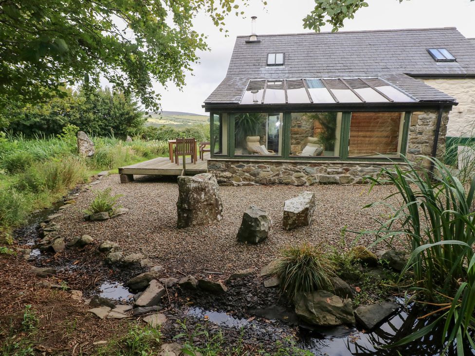 A garden with a deck and rocks at The Dovecote Llanychaer near Fishguard