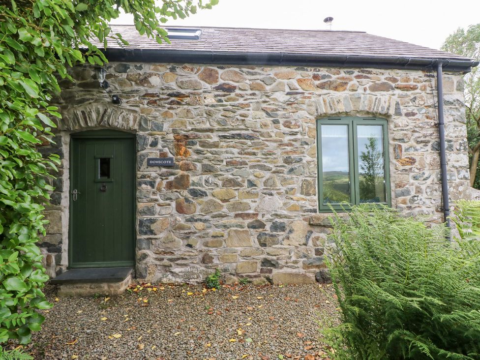 An exterior view of a stone cottage with a green door at The Dovecote near Fishguard