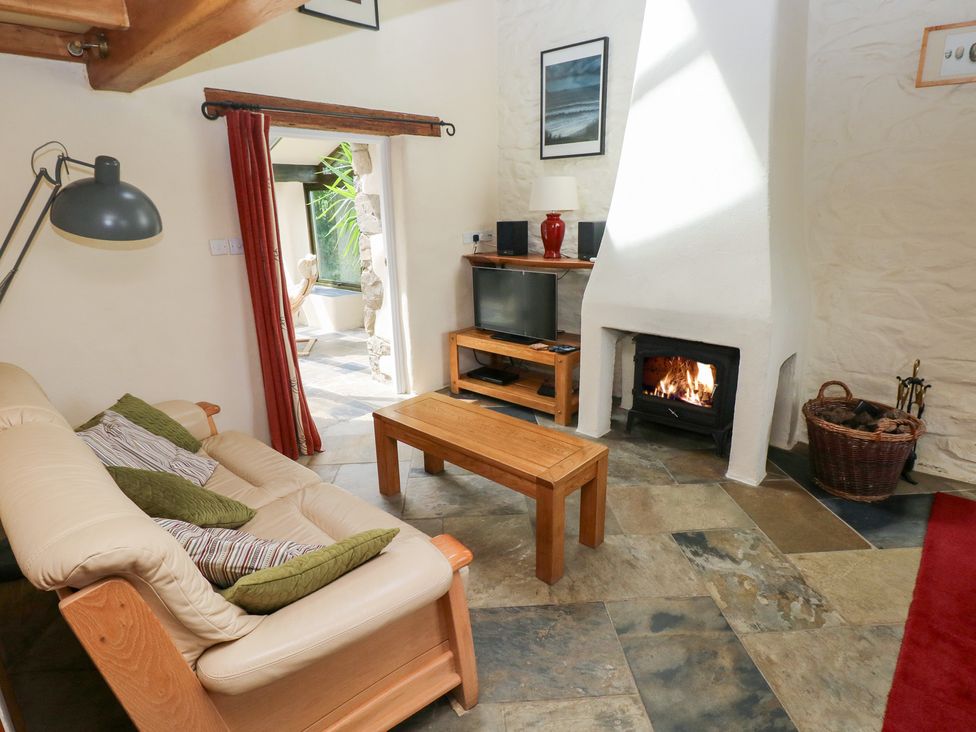 A living room with a sofa, coffee table, and television at The Dovecote in Llanychaer near Fishguard