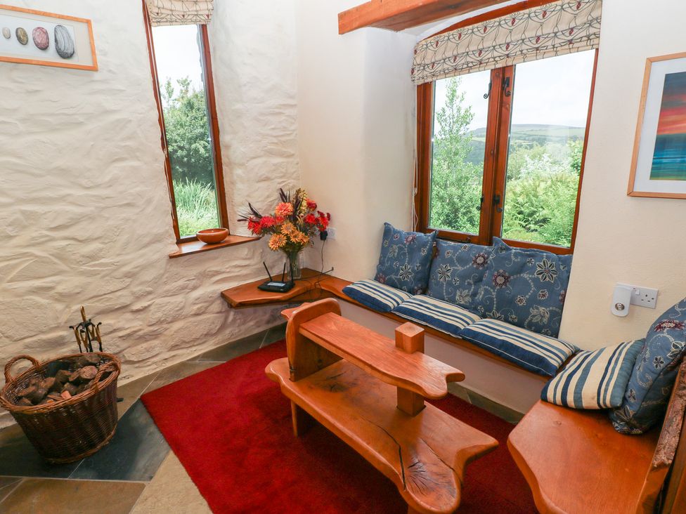 A snug area with seating and decorative flowers at The Dovecote Llanychaer near Fishguard