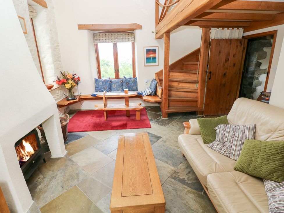 A living room with a fireplace and seating area at The Dovecote in Llanychaer near Fishguard