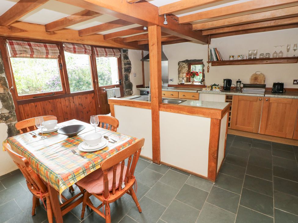 A kitchen with wooden cabinets and a table set at The Dovecote in Llanychaer near Fishguard