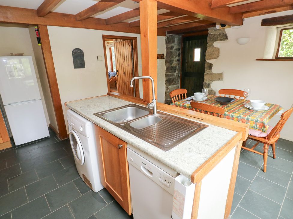 A kitchen with appliances and a dining area at The Dovecote in Llanychaer near Fishguard