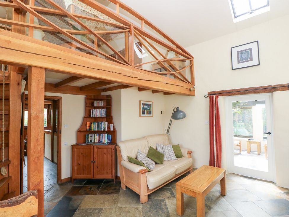 A living room with a sofa, coffee table, and bookshelf at The Dovecote near Llanychaer Fishguard