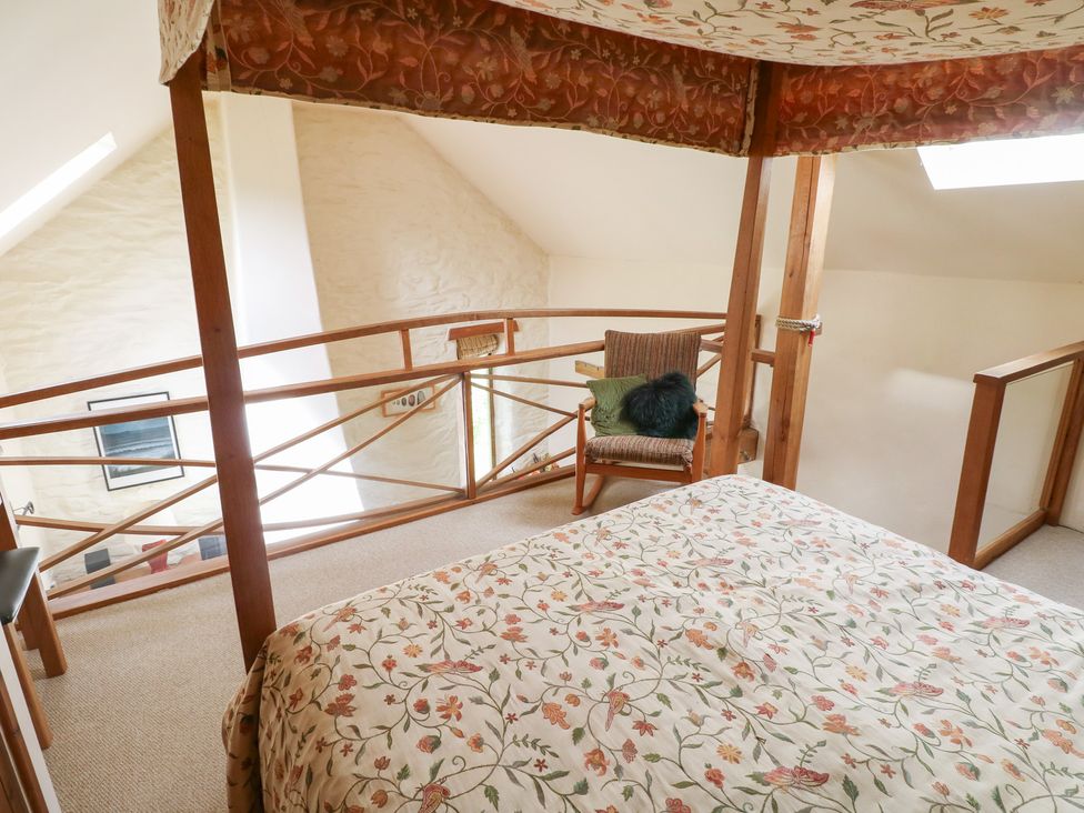 A bedroom with a bed and chair at The Dovecote in Llanychaer near Fishguard