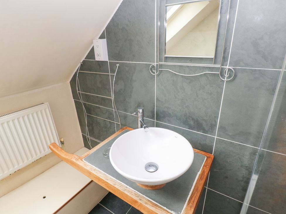 A bathroom with a wash basin and mirror at The Dovecote in Llanychaer near Fishguard
