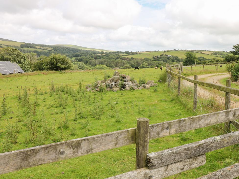 An outdoor scene with a field, solar panels, and a fence at The Dovecote near Llanychaer Fishguard