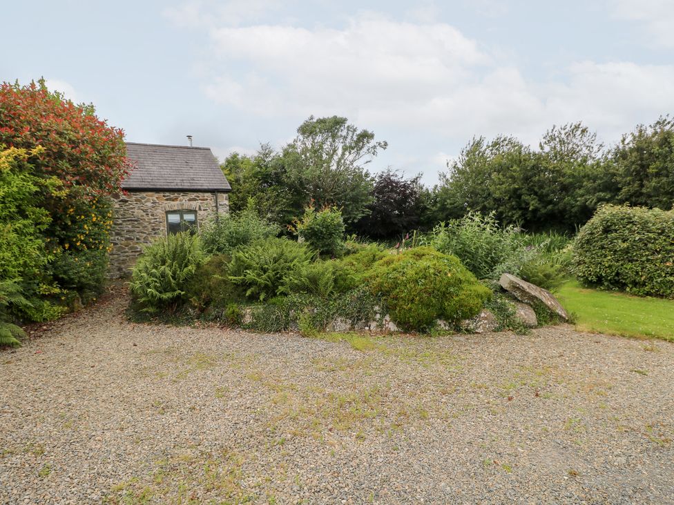 A stone building surrounded by gravel and plants at The Dovecote in Llanychaer near Fishguard