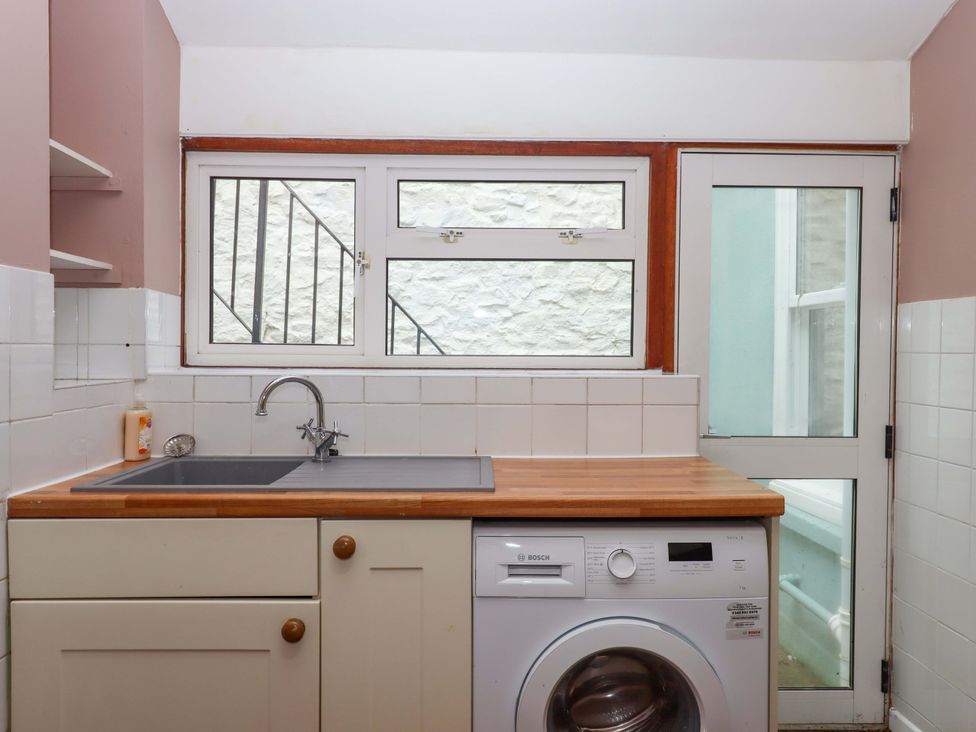 A kitchen with a sink and washing machine at Captains Cottage Brixham