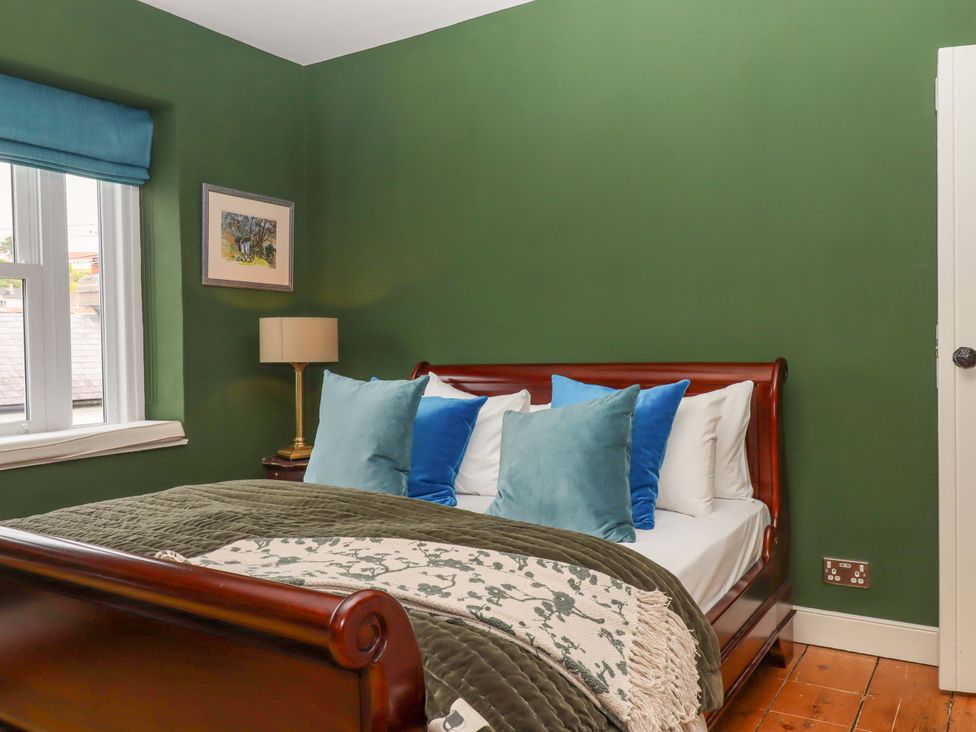 A bedroom with a bed and a lamp at Captains Cottage in Brixham