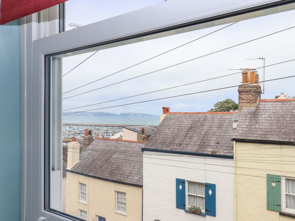A view from a window showing rooftops and the sea at Captains Cottage Brixham