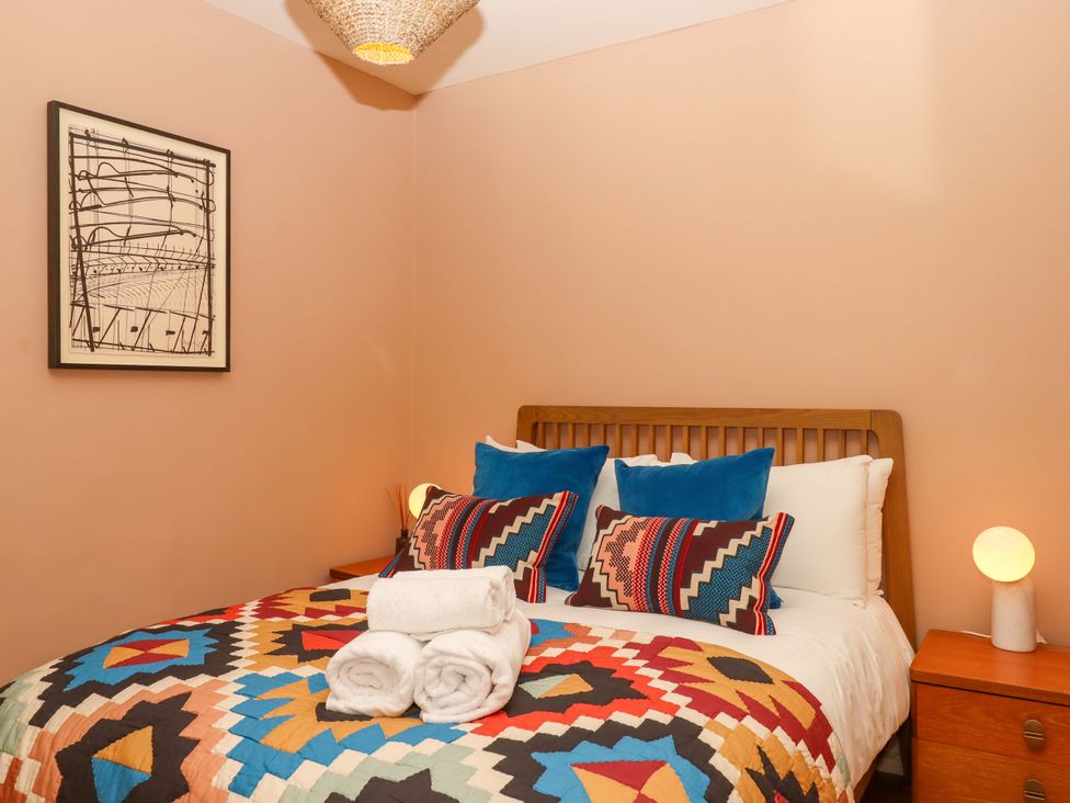 A bedroom with a bed and artwork on the wall at Captains Cottage in Brixham