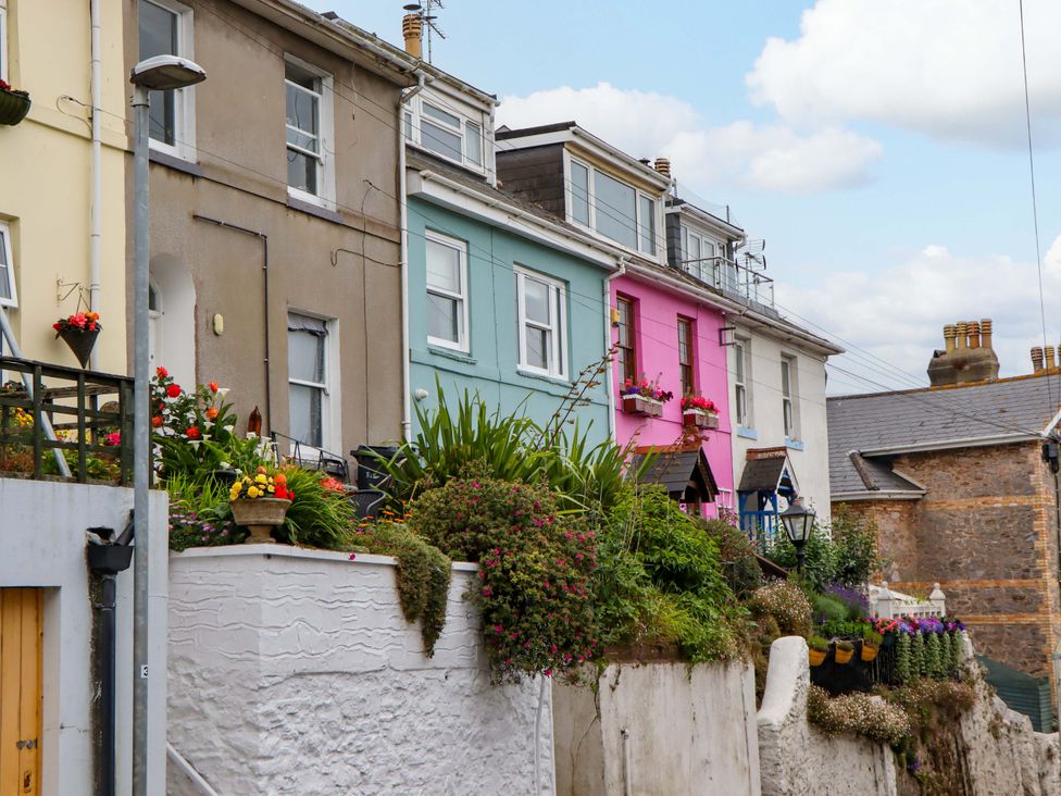 A row of colorful houses with flowers in pots at Captains Cottage Brixham