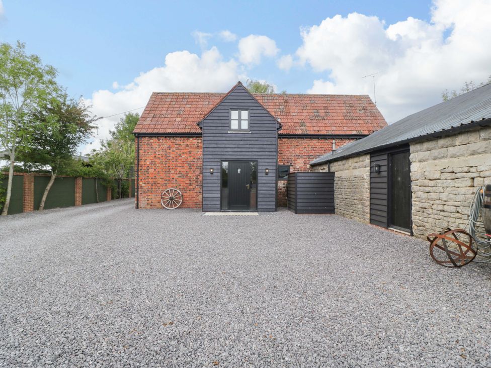 A house with gravel parking area and trees at The Sty Shades Farm near Malmesbury