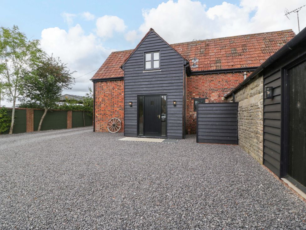 A house with a gravel area and trees at The Sty Shades Farm near Malmesbury