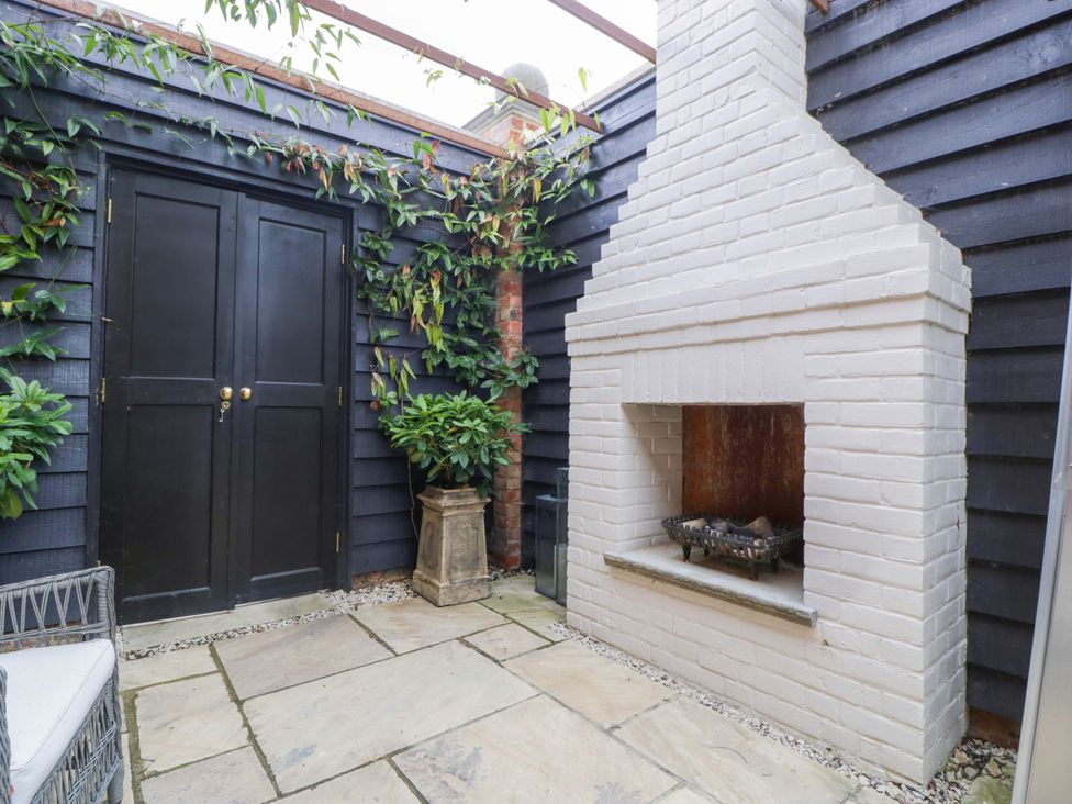 An outdoor area with a fireplace and a door at The Sty near Shades Farm Malmesbury