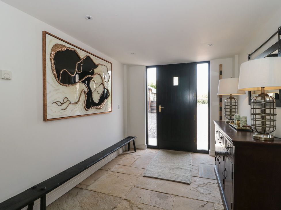 An entrance hall with a door and a bench at The Sty near Shades Farm near Malmesbury