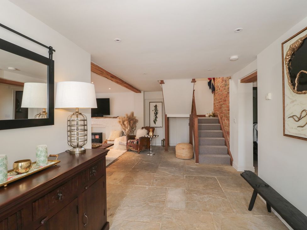 A living room with a staircase and fireplace at The Sty Shades Farm near Malmesbury
